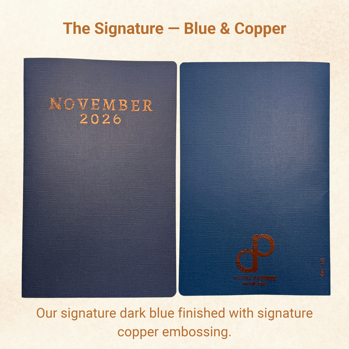 The Signature planner cover in textured navy blue with copper embossed November 2026 and copper logo on the back
